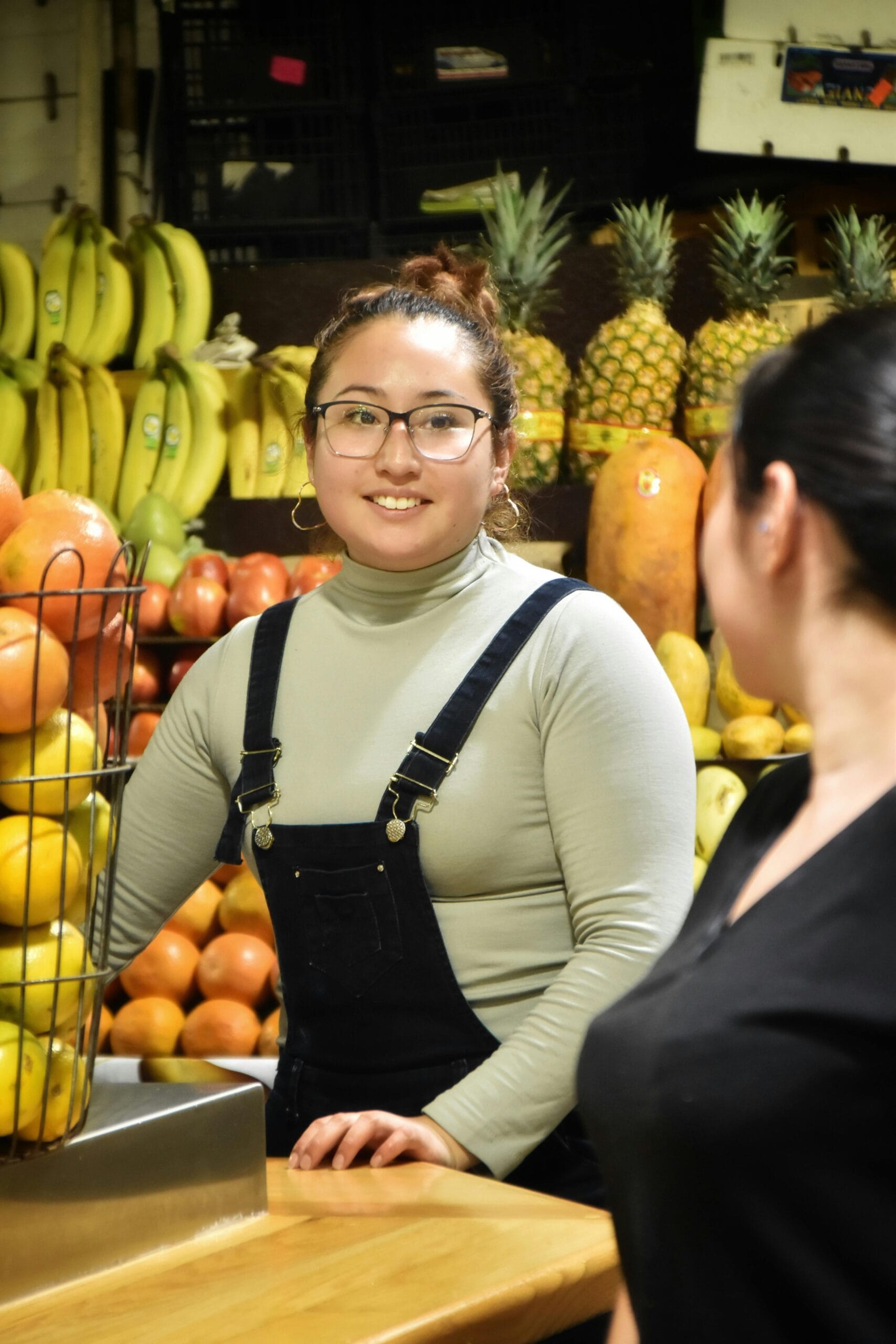 Market vendor smiling at a customer in a fruit shop in Ciudad de México.